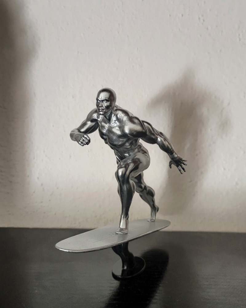 Figura 3D por encargo de Silver Surfer (Estela Plateada) con acabado profesional de efecto cromado sobre tabla de surf.